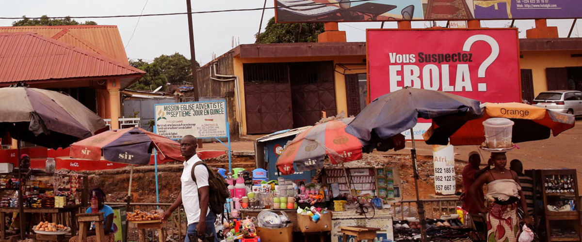 Street view with poster "Do you suspect Ebola?", Conakry